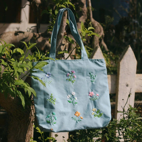 Linen tote bag with a hand-embroidered botanical garden design
