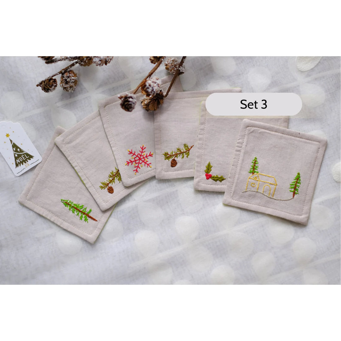 Set of six beige linen coasters with embroidered Christmas designs — hand-embroidered by The Thread Nest