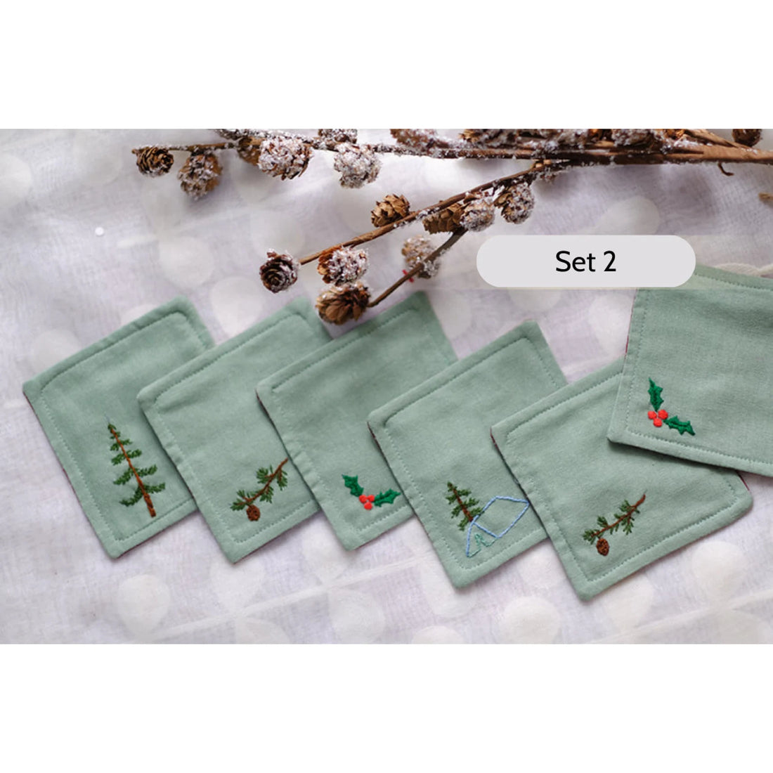 Set of six beige linen coasters with embroidered Christmas designs — hand-embroidered by The Thread Nest