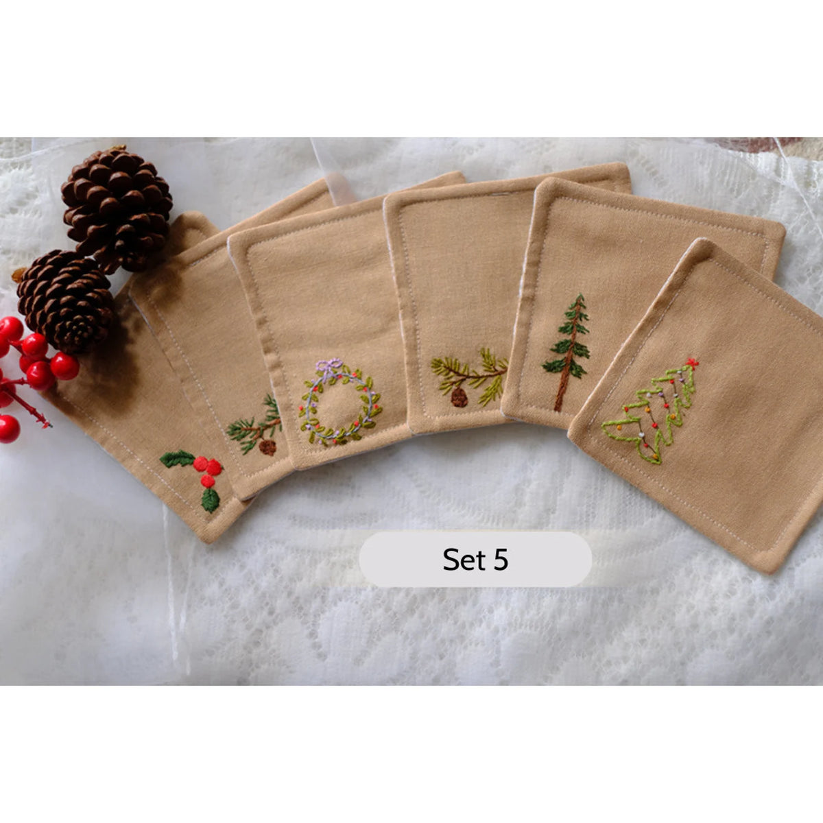 Set of five beige linen coasters with embroidered Christmas designs — hand-embroidered by The Thread Nest