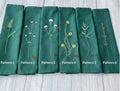 Six green linen tea towels with embroidered floral patterns and names — hand-embroidered by The Thread Nest