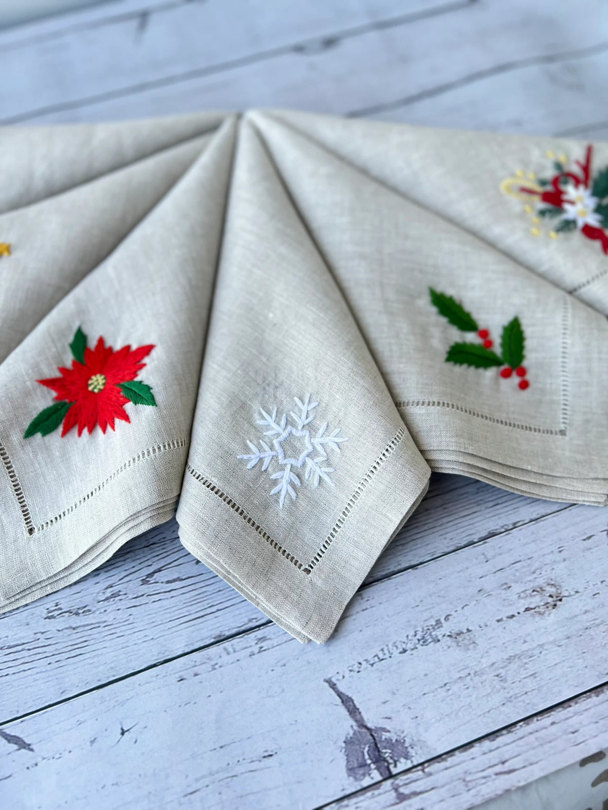 Set of six linen napkins with embroidered Christmas designs — hand-embroidered by The Thread Nest