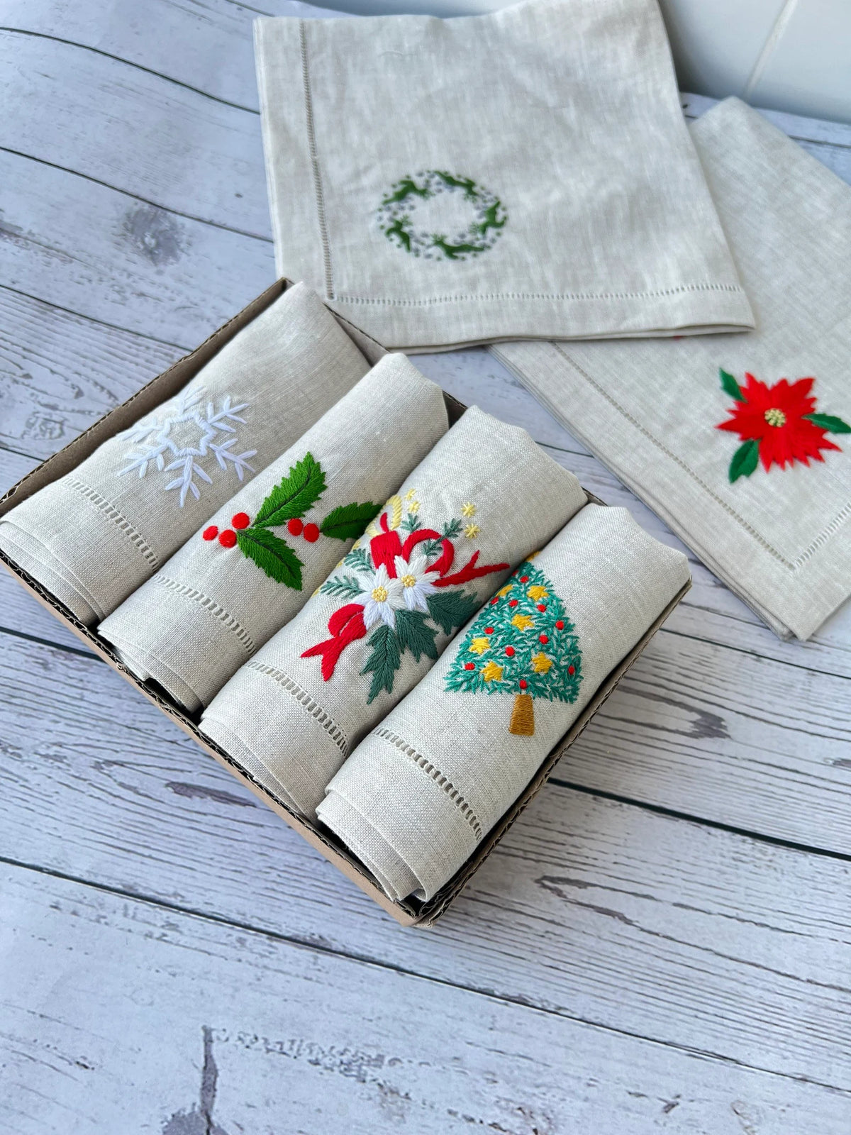 Set of six linen napkins with embroidered Christmas designs — hand-embroidered by The Thread Nest