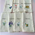Set of nine embroidered tea towels with floral designs including a grape vine, a bee and a daisy — hand-embroidered by The Thread Nest
