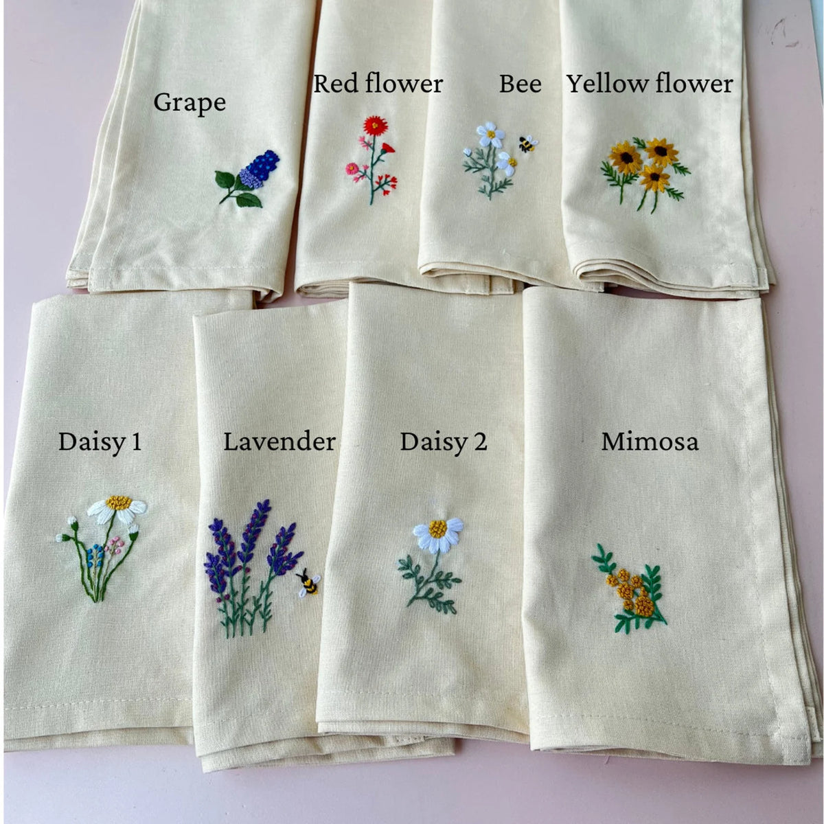 Set of nine embroidered tea towels with floral designs including a grape vine, a bee and a daisy — hand-embroidered by The Thread Nest