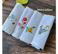 Set of four white linen tea towels with embroidered floral designs — hand-embroidered by The Thread Nest
