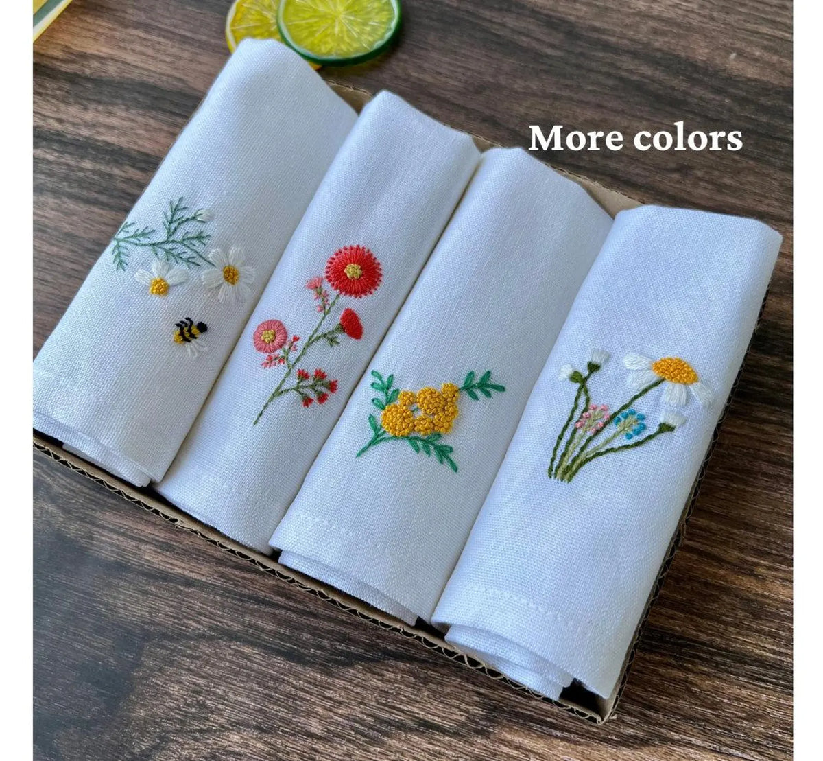 Set of four white linen tea towels with embroidered floral designs — hand-embroidered by The Thread Nest