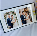 A black photo album open to two pages with wedding photos — hand-embroidered by The Thread Nest