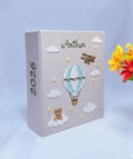 A light gray photo album with an embroidered hot air balloon and a teddy bear on a cloud — hand-embroidered by The Thread Nest