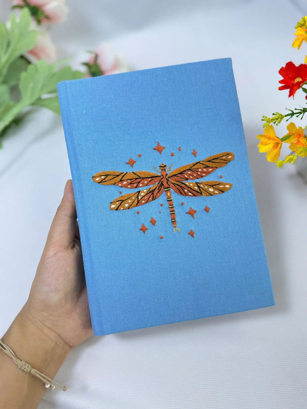 Dragonfly Embroidered Journal by The Thread Nest, pale blue linen cover with a hand-embroidered dragonfly, photo 1