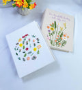 Two rectangular fabric-covered albums — hand-embroidered by The Thread Nest