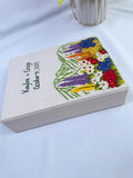 An off-white keepsake box with an embroidered floral design and two names — hand-embroidered by The Thread Nest