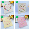 Four photo albums with embroidered floral wreaths and personalized names — hand-embroidered by The Thread Nest