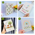 Four photo albums with embroidered daisies and stitched names — hand-embroidered by The Thread Nest
