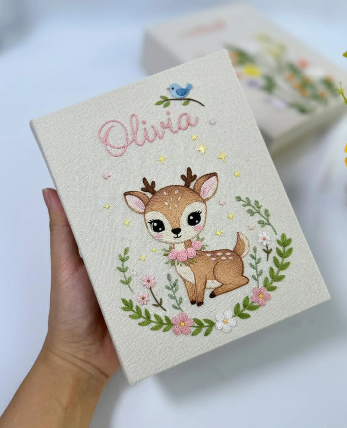 A beige keepsake box with an embroidered deer in a floral wreath — hand-embroidered by The Thread Nest