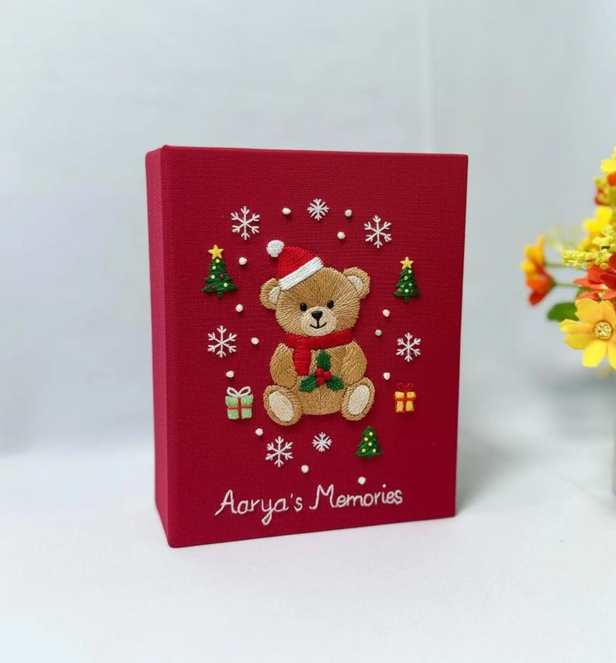 A red keepsake box with an embroidered teddy bear in a Santa hat — hand-embroidered by The Thread Nest