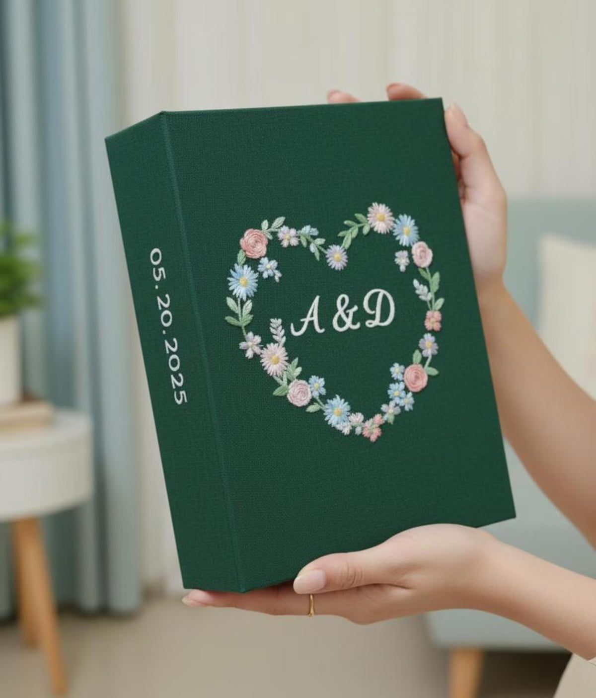 A dark green keepsake box with a heart of embroidered flowers and two initials — hand-embroidered by The Thread Nest