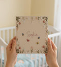 A square beige canvas with floral embroidery, bees, butterflies and a name — hand-embroidered by The Thread Nest