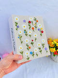 A beige keepsake box with embroidered daisies and colourful flowers — hand-embroidered by The Thread Nest