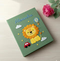 A green book with a stitched name, an embroidered lion and a hot air balloon — hand-embroidered by The Thread Nest