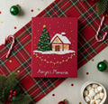 A red Christmas journal with an embroidered house and Christmas tree — hand-embroidered by The Thread Nest