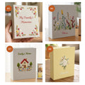 A collection of embroidered photo albums, one held in a hand — hand-embroidered by The Thread Nest