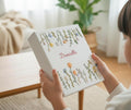 A white keepsake box with embroidered flowers in yellow, blue and orange — hand-embroidered by The Thread Nest