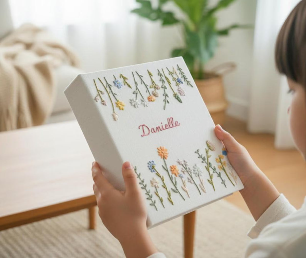 A white keepsake box with embroidered flowers in yellow, blue and orange — hand-embroidered by The Thread Nest