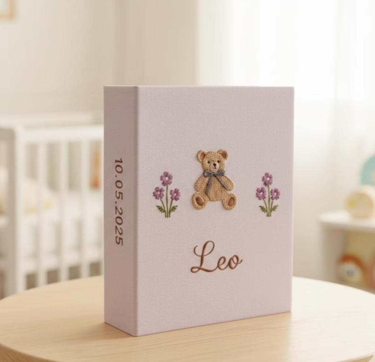 A light purple photo album with an embroidered brown teddy bear and the name Leo — hand-embroidered by The Thread Nest