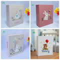 Four personalized photo albums with an embroidered goose and a bunny — hand-embroidered by The Thread Nest