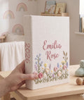 A linen-covered photo album with embroidered flowers and a name in pink thread — hand-embroidered by The Thread Nest