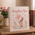 A cream-colored photo album with an embroidered rabbit and a stitched name — hand-embroidered by The Thread Nest