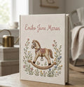 A cream-colored book with an embroidered name in pink script and floral details — hand-embroidered by The Thread Nest
