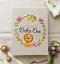 A beige book with an embroidered wreath of lemons, leaves and flowers — hand-embroidered by The Thread Nest