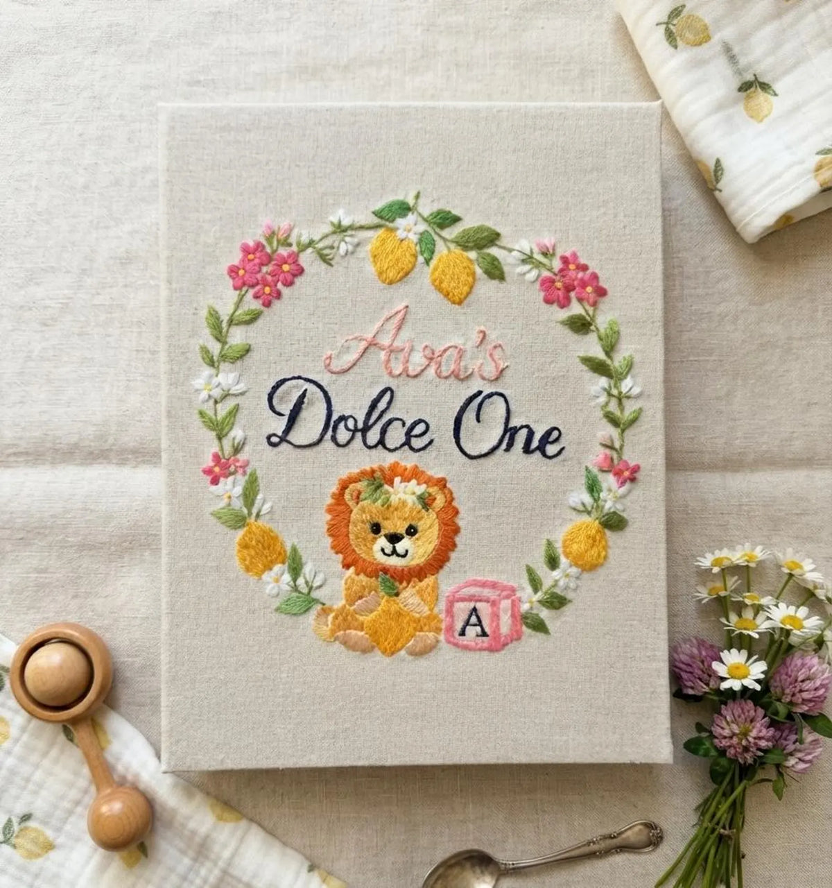 A beige book with an embroidered wreath of lemons, leaves and flowers — hand-embroidered by The Thread Nest