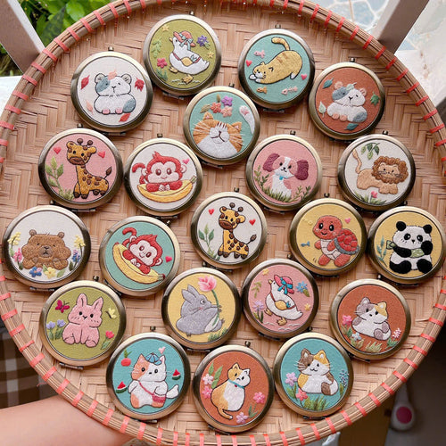 Compact pocket mirror with a hand-embroidered animal design on linen
